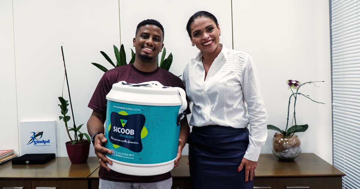 José recebeu um cooler Sicoob MetalCred das mãos da diretora Priscila Sena, recompensa por ter participado do Sindpd On Fire, em Campinas.